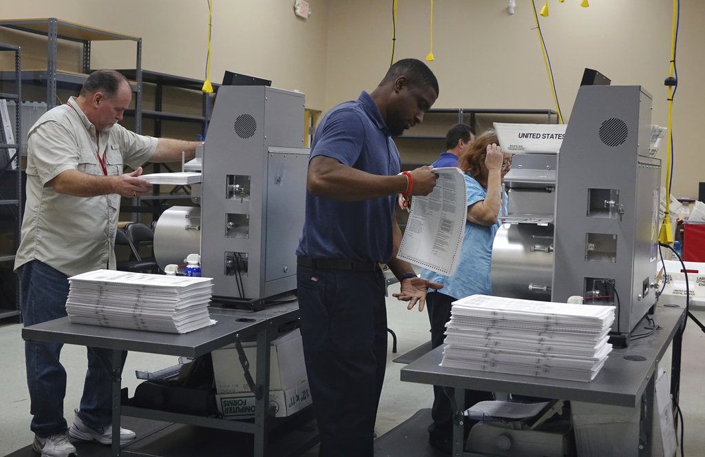 Trabajadores electorales colocan boletas en máquinas de conteo, el domingo 11 de noviembre de 2018, en la oficina de la supervisora de las elecciones del condado Broward, en Lauderhill, Florida. (Joe Cavaretta /South Florida Sun-Sentinel vía AP)