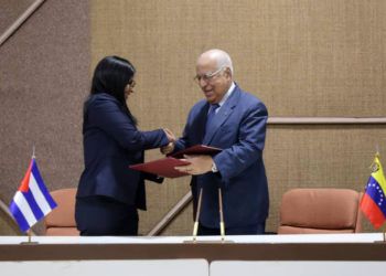 Delcy Rodríguez (izq), Vicepresidenta Ejecutiva de Venezuela, saluda a Ricardo Cabrisas, vicepresidente cubano del Consejo de Ministros, tras el acuerdo del plan de cooperación bilateral para 2019. Foto: @CancilleriaVE / Twitter.