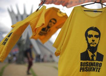 Camisetas con la imagen del presidente electo de Brasil, Jair Bolsonaro, se exhiben para la venta frente a la Catedral de Brasilia, el viernes 28 de diciembre de 2018. (AP Foto/Eraldo Peres)