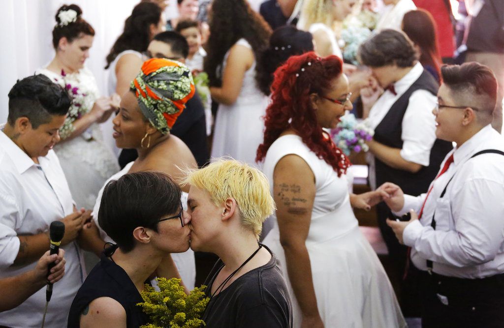 Varias parejas se besan y celebran durante una ceremonia colectiva de 40 parejas del mismo sexo en Sao Paulo, Brasil, el sábado 15 de diciembre del 2018. (AP Foto/Nelson Antoine)