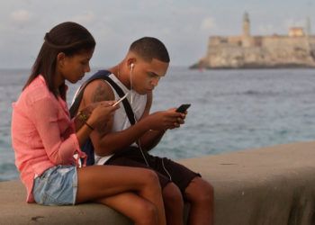 Una pareja de jóvenes se conecta a internet desde el malecón, el 27 de diciembre de 2018, en La Habana. Foto: Yander Zamora / EFE.