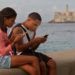 Una pareja de jóvenes se conecta a internet desde el malecón, el 27 de diciembre de 2018, en La Habana. Foto: Yander Zamora / EFE.