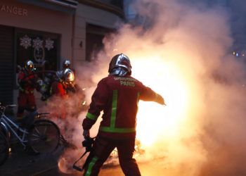 Bomberos intentan extinguir el fuego de un vehículo incendiado por manifestantes durante un enfrentamiento con policías antidisturbios en París, el sábado 8 de diciembre de 2018. Foto: Thibault Camus / AP.