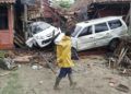 Un aldeano camina por unos carros dañados por un tsunami, en Carita, Indonesia, el domingo 23 de diciembre del 2018. (AP Foto/Dian Triyuli Handoko)