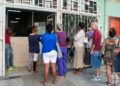 Personas esperan la venta de pan liberado en la panadería de la calle Reina, en La Habana. Foto: Otmaro Rodríguez.