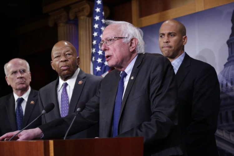 El senador independiente Bernie Sanders, al centro, acompañado, de izquierda a derecha, por los representantes demócratas Peter Welch y Elijah Cummings y el senador demócrata Cory Booker, habla con la prensa antes de presentar una propuesta de ley para reducir los precios de los medicamentos, el jueves 10 de enero del 2019, en el Capitolio en Washington. Foto: J. Scott Applewhite / AP.