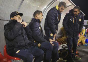 El técnico Diego Maradona (izquierda) observa el partido de su equipo, Dorados de Sinaloa, contra Juárez por las semifinales de la segunda división de México en Ciudad Juárez, México, el 24 de noviembre de 2018. Foto: Christian Torres / AP.