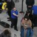 Una agente de la Administración de Seguridad en el Transporte, centro, da instrucciones a los pasajeros en un punto de revisión en el Aeropuerto Internacional John F. Kennedy, en Nueva York. Foto: Mark Lennihan / AP.