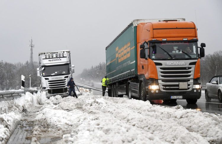 Dos camioneros se ayudan después de haber quedado atrapados por una fuerte nevada en la autopista A8 cerca de Holzkirchen, en el sur de Alemania, el lunes 7 de enero de 2019. Foto: Tobias Hase / dpa vía AP.