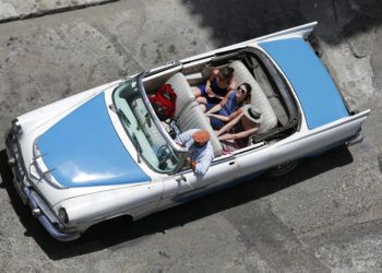 En esta imagen tomada el 13 de mayo de 2015, turistas pasean en un auto clásico descapotable por La Habana. Foto: Desmond Boylan / AP.