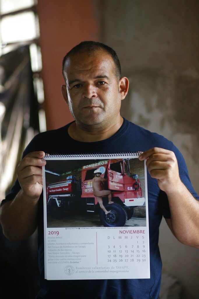 El jefe del departamento de bomberos, Alcides Britez, muestra la página del calendario en la que posa desnudo, en Asunción, Paraguay. Foto: Jorge Saenz / AP.