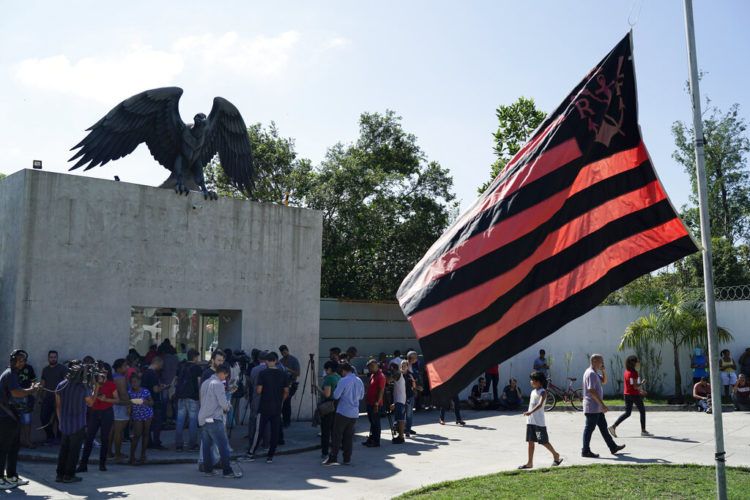 Amigos, fanáticos y periodistas rodean la entrada del centro de entrenamiento del club de fútbol Flamengo a la espera de información sobre un incendio en las instalaciones, Río de Janeiro, Brasil, viernes 8 de febrero de 2019. (AP Foto/Leo Correa)