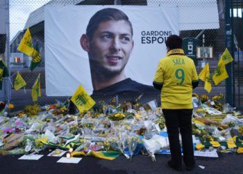 Un aficionado del club francés Nantes se detiene frente a la imagen del futbolista argentino Emiliano Sala junto a la frase "mantengamos la esperanza" afuera del estadio La Beaujoire, antes del partido de la liga francesa entre Nantes y Saint-Etienne, en Nantes, Francia. Foto: Thibault Camus / AP.