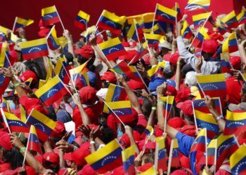 Seguidores del presidente Nicolás Maduro ondean banderas de Venezuela durante un acto en Caracas, Venezuela, el 2 de febrero de 2019. Foto: Ariana Cubillos / AP.