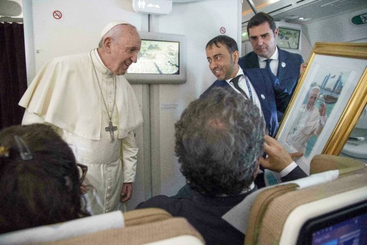 El Papa Francisco recibe un regalo de un periodista a bordo del avión papal cuando viaja de Abu Dabi a Roma el 5 de febrero del 2019. Foto: Luca Zennaro / Pool vía AP.