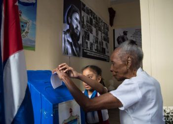 Una señora débil visual vota en un colegio electoral de la Habana Vieja, auxiliada por una niña, en el referendo constitucional cubano el 24 de febrero de 2019. Foto: Otmaro Rodríguez.