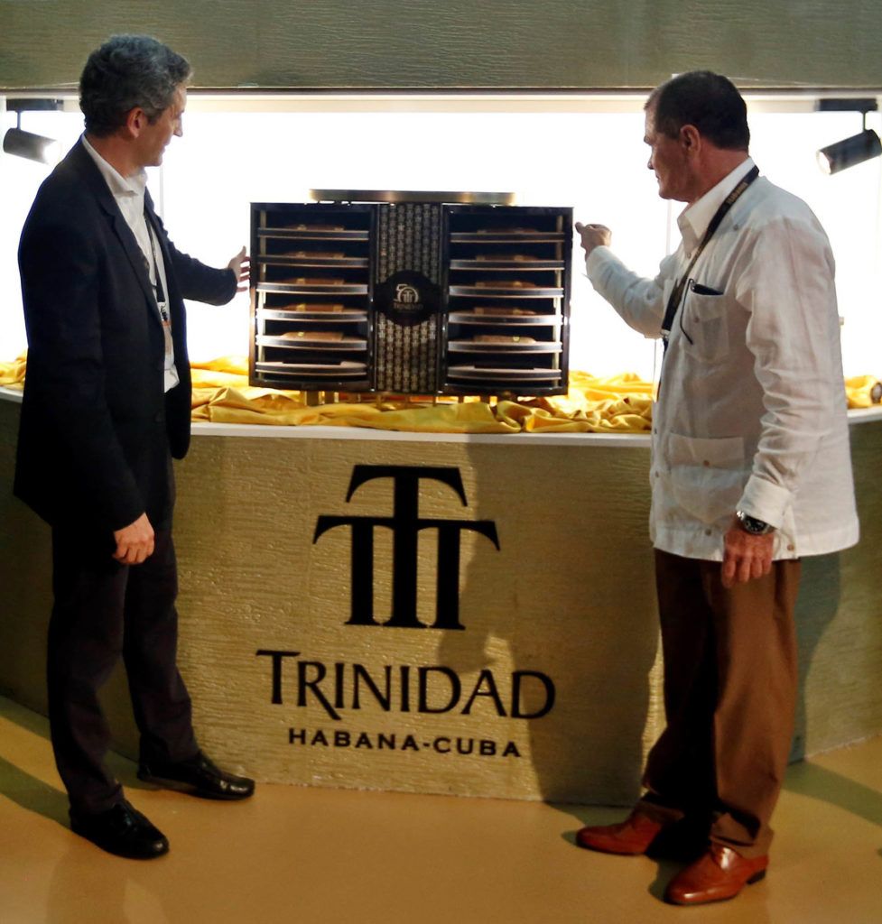 Los copresidentes de Habanos S.A., Luis Sánchez-Harguindey (i), de España, e Inocente Núñez (d), de Cuba, muestran a los presentes el nuevo humidor de la colección Trinidad, en su 50 aniversario, durante la inauguración del XXI Festival del Habano. Foto: Ernesto Mastrascusa / EFE.