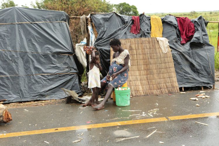 Sobrevivientes del ciclón Idai, junto a un refugio improvisado junto a una carretera cerca de Nhamatanda, a unos 50 kms de Beira, Mozambique, el 22 de marzo de 2019. (AP Foto/Tsvangirayi Mukwazhi)