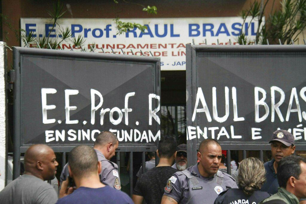 Policías custodian la entrada a la Escuela Estatal Raul Brasil en Suzano, Brasil, el miércoles, 13 de marzo del 2019. Dos adolescentes con capuchas abrieron fuego en la escuela en el sur de Brasil, matando a seis personas antes de suicidarse, dijeron las autoridades. (Mauricio Sumiya/Futura Press via AP)