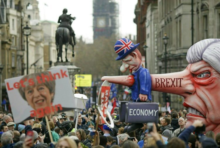 Cientos de miles de personas protesta durante una marcha anti-Brexit en la Plaza Trafalgar, en Londres, el sábado 23 de marzo del 2019. A la derecha se ve un muñeco gigante con el rostro de la primera ministro británica Theresa May, que también aparece en un cartel a la izquierda. Foto: Tim Ireland / AP.