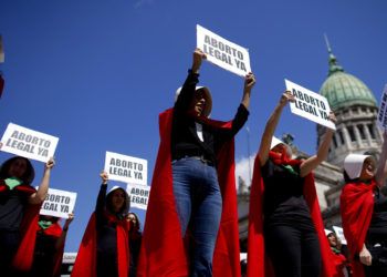 Activistas por el aborto libre vestidas como personajes de la novela convertida en serie de televisión "El cuento de la criada", sostienen pancartas en el Día Internacional de la Mujer en Buenos Aires, Argentina, el viernes 8 de marzo de 2018. Foto: Natacha Pisarenko / AP.