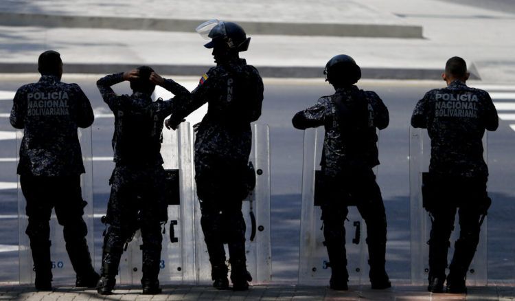 Policías venezolanos asumen posiciones antes de una marcha opositora en Caracas el 19 de marzo del 2019. Foto: Natacha Pisarenko / AP