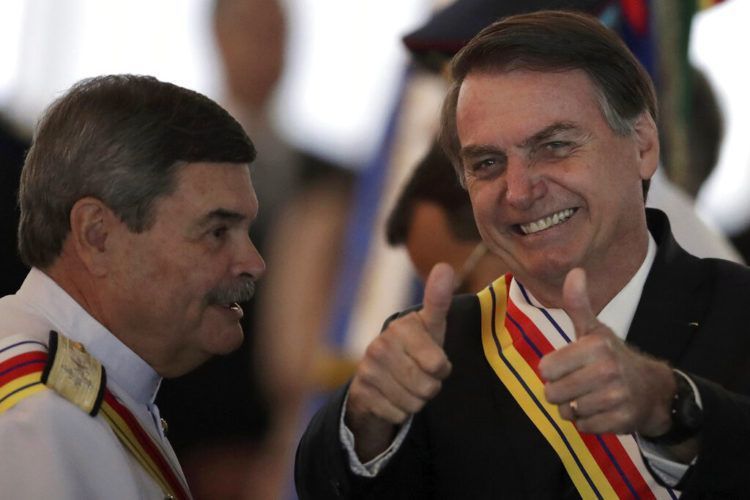 En esta imagen, tomada el 28 de marzo de 2019, el presidente de Brasil, Jair Bolsonaro, levanta los pulgares junto al almirante Marcus Vinicius Oliveira dos Santos, presidente de la Suprema Corte Militar, que le entregó a Bolsonaro la Orden Judicial al Mérito Militar, en Brasilia, Brasil. Bolsonaro, un excapitán del ejército que dijo añorar la dictadura (1964-1985), pidió el 25 de marzo al Ministerio de Defensa que organice las "debidas conmemoraciones" por el aniversario del golpe de Estado militar de 1964 el 31 de marzo. (AP Foto/Eraldo Peres)