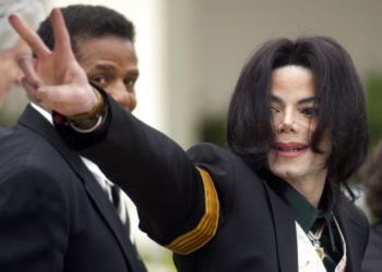 En esta foto del 2 de marzo del 2005, Michael Jackson saluda a sus fans al llegar a su juicio por abuso de menores en la Corte Superior del Condado de Santa Bárbara en Santa María, California. Foto: Michael A. Mariant / AP.