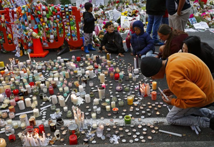 Estudiantes encienden velas durante una vigila para recordar a las víctimas del tiroteo del viernes afuera de la mezquita de Al Noor en Christchurch, Nueva Zelanda, el lunes 18 de marzo de 2019. Foto: Vincent Yu / AP.