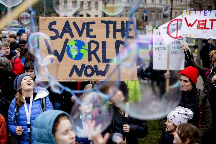 Jóvenes se manifiestan a favor de la adopción de medidas contra el cambio climático con un letrero que dice: "Salven al mundo ahora" durante una concentración en Berlín, Alemania, el viernes 22 de marzo de 2019. Foto: Christoph Soeder / dpa vía AP.