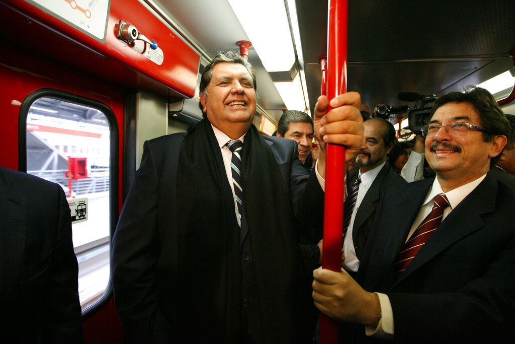 En esta foto de archivo del 11 de julio de 2011 el entonces presidente saliente de Perú, Alan García, a la izquierda, viaja en el sistema de tren eléctrico en Lima, Perú. (AP Foto / Martín Mejía, Archivo)