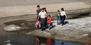 Una familia de migrantes cruza el río Bravo el martes 16 de abril de 2019, en la fronteriza Ciudad Juárez, en el estado de Chihuahua. Foto: David Peinado / EFE.