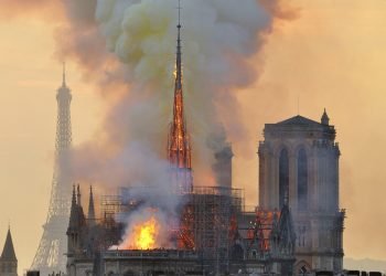 En esta fotografía del lunes 15 de abril de 2019 se muestra la Torre Eiffel en el fondo y una columna de humo y llamas que salen de un incendio en la catedral de Notre Dame en París. Foto: Thierry Mallet/AP