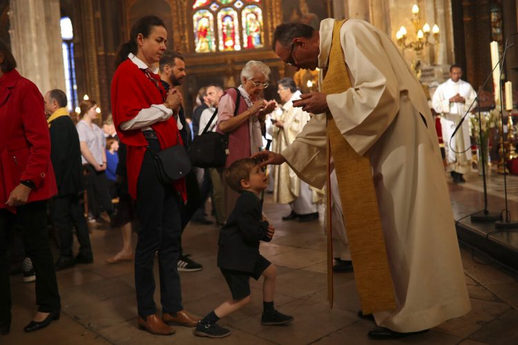 Sacerdotes dan la comunión a los feligreses durante la misa del domingo de Pascua en la grandiosa iglesia Saint-Eustache en París, el domingo 21 de abril de 2019. Foto: Francisco Seco/AP.