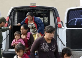 En esta fotografía del viernes 12 de abril de 2019, un agente de la Patrulla Fronteriza ayuda a migrantes a salir de una camioneta en la Misión de Rescate Gospel en Las Cruces, Nuevo México. (Blake Gumprecht/The Las Cruces Sun News vía AP)