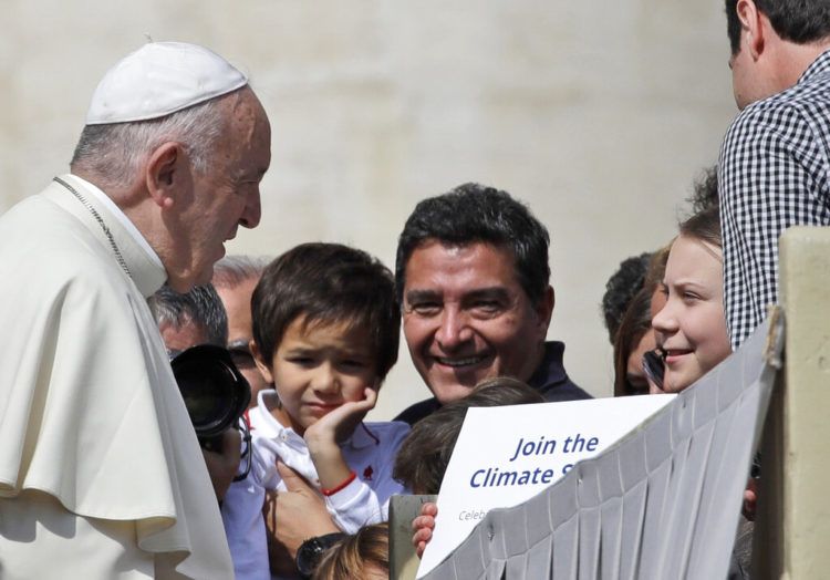 El papa Francisco saluda a la joven activista climática sueca Greta Thunberg, a la derecha, durante su audiencia pública semanal en la Plaza de San Pedro del Vaticano, el miércoles 17 de abril de 2019. Foto: Alessandra Tarantino / AP.