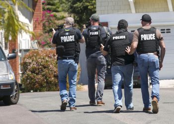 Agentes de policía de San Diego fuertemente armados se acercan a la casa donde se cree vivía John T. Earnest, de 19 años, sospechoso del tiroteo en una sinagoga de Poway, el sábado 27 de abril de 2019 en San Diego, California. Foto: John Gibbins/The San Diego Union-Tribune vía AP.