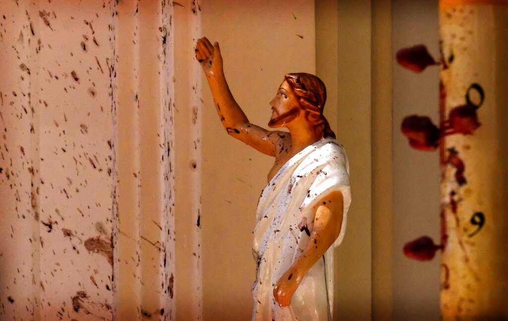 Manchas de sangre se ven en el muro y en una estatua de Jesucristo después de una explosión en la iglesia de San Sebastián, en Colombo, Sri Lanka, el domingo 21 de abril de 2019. (AP Foto)