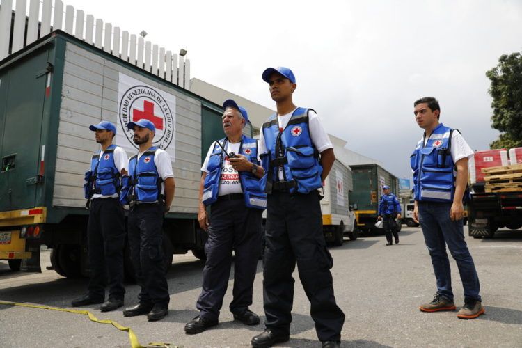 Voluntarios coordinan la llegada a una bodega de los camiones que transportan la ayuda humanitaria de la Federación Internacional de Sociedades de la Cruz Roja y de la Media Luna en Caracas, Venezuela, el martes 16 de abril de 2019. Foto: Ariana Cubillos / AP.