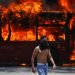 Un manifestante antigubernamental camina cerca de un autobús que fue incendiado por opositores al presidente de Venezuela, Nicolás Maduro, en Caracas, el martes 30 de abril de 2019.  Foto:  Fernando Llano / AP.