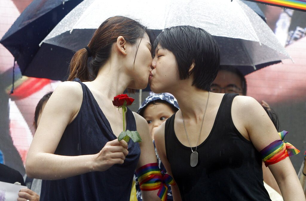 Dos muejres, activistas en favor del matrimonio homosexual, se besan en el exterior del parlamento de Taiwán, en Taipei, el 17 de mayo de 2019, tras la aprobación de una ley que legaliza las uniones entre personas del mismo sexo. (AP Foto/Chiang Ying-ying)