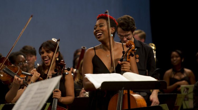 Integrantes de la Cuban American Youth Orchestra (CAYO) ríen durante una presentación en el Teatro Nacional de La Habana, el sábado 25 de mayo de 2019 en su primera gira por la isla. La orquesta juvenil cubano-estadounidense tiene músicos de importantes instituciones de ambos países como New World Symphony, Juilliard, el Instituto Superior de Arte de Cuba y la Orquesta de Cámara de Cuba. (Foto AP/Ismael Francisco)