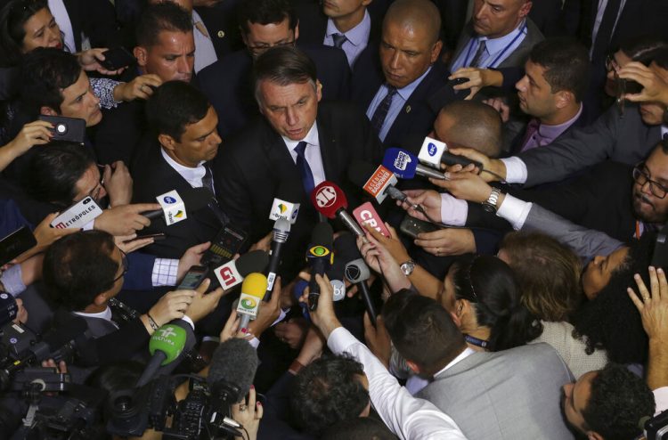 El presidente de Brasil Jair Bolsonaro habla con la prensa después de aprobar un segundo decreto que elimina ciertas restricciones de posesión de armas de fuego en el palacio presidencial Planalto en Brasilia, Brasil, el martes 7 de mayo de 2019. (AP Foto/Eraldo Peres)