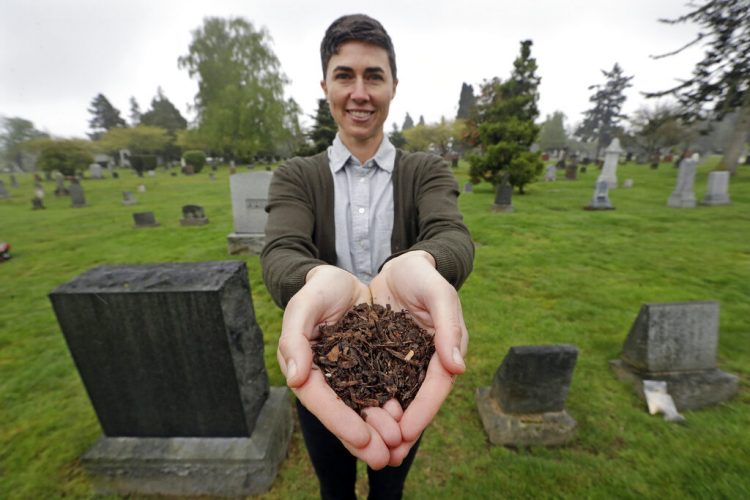 Katrina Spade, fundadora y directora general de Recompose, una compañía que espera utilizar el compost como una alternativa al entierro o cremación de restos humanos, posa para una fotografía en un cementerio de Seattle, mientras muestra el compost que quedó de los restos de una vaca, utilizando una combinación de astillas de madera, alfalfa y paja, 19 de abril de 2019. Foto: Elaine Thompson / AP.