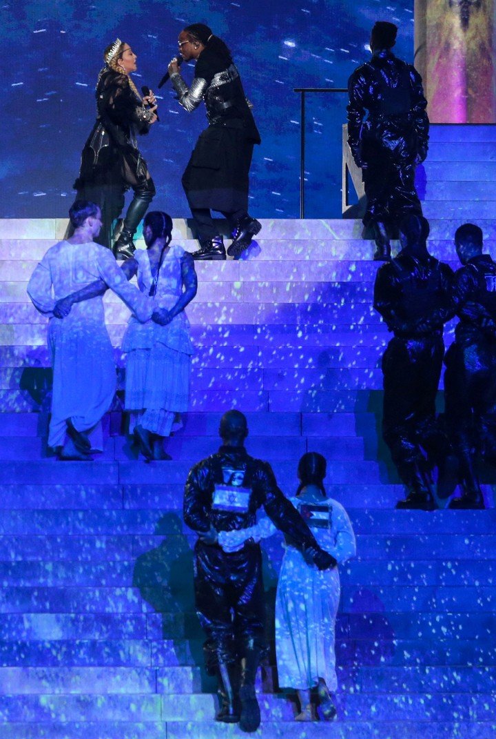 Los bailarines abrazados con las banderas israelí y palestina en sus espaldas. Foto: AFP.