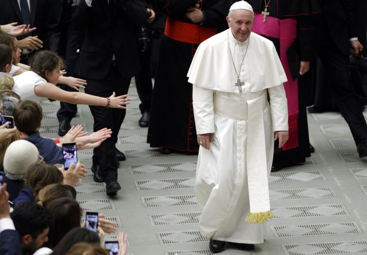 Fieles tratan de tocar al papa Francisco durante una audiencia con participantes de una peregrinación en el Aula Paulo VI en el Vaticano, sábado 25 de mayo de 2019. El Papa dijo que el aborto equivale a “contratar a un asesino”. Foto: Andrew Medichini / AP.