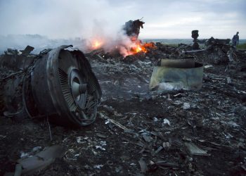 Un hombre camina entre los escombros de un avión derrivado cerca de la localidad de Hrabove, Ucrania, el 17 de julio de 2014. Foto: Dmitry Lovetsky / AP.