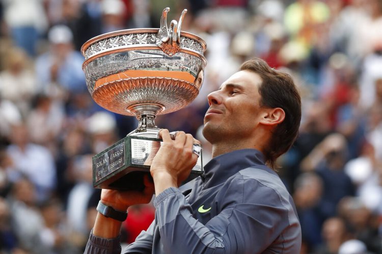 El español Rafael Nadal levanta el trofeo mientras celebra su 12mo título del Abierto de Francia tras imponerse a Dominic Thiem en cuatro sets, en París, el domingo 9 de junio de 2019. (AP Foto/Christophe Ena)