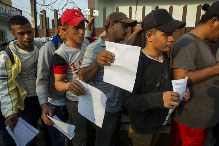 Migrantes centroamericanos hacen fila afuera de la Comisión Mexicana de Ayuda al Refugiado en Tapachula para obtener los documentos necesarios que les permiten permanecer en México, el jueves 20 de junio de 2019. Foto: Oliver de Ros / AP.