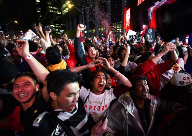 Numerosos aficionados festejan en Jurassic Park, afuera de la Arena Scotiabank en Toronto la victoria de los Raptors de Toronto por 114-110 sobre los Warriors de Golden State en el sexto partido para conquistar el título de la NBA de visitantes en Oakland, California. (Nathan Denette/The Canadian Press vía AP)